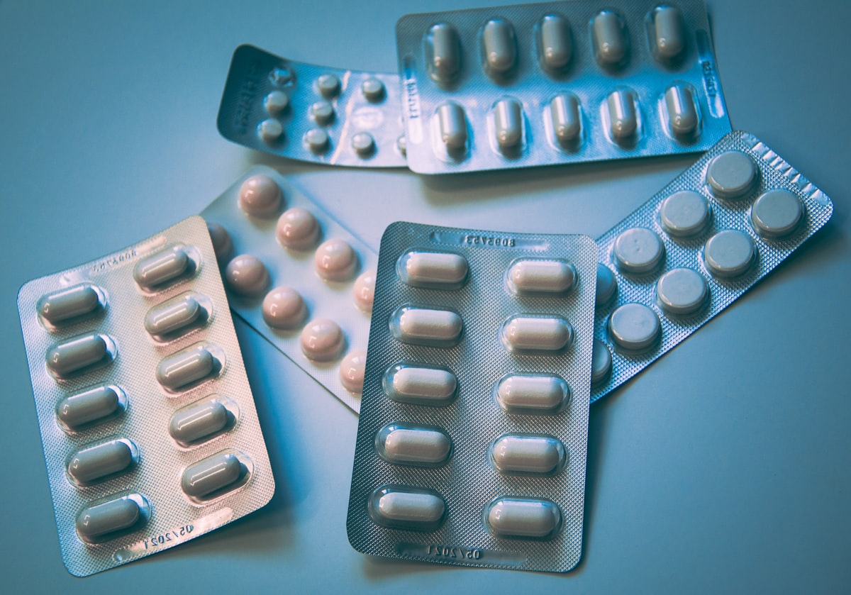 A weekly pill organizer beside an over-the-counter pain reliever bottle on a clean counter